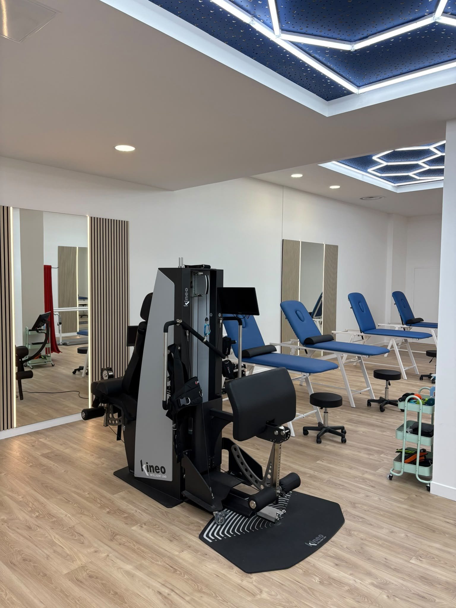 Machine Kineo Intelligent Load sur le plateau technique, tables de soins bleues en arrière-plan